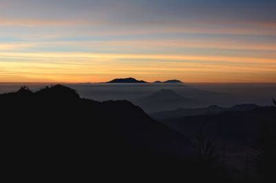 Scenic view of silhouette mountains against sky during sunset