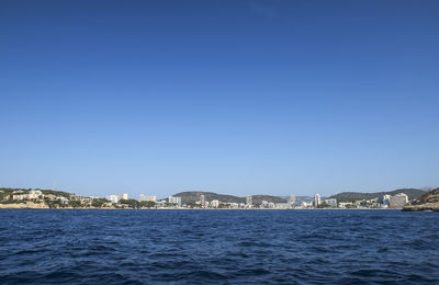 City by sea against clear blue sky