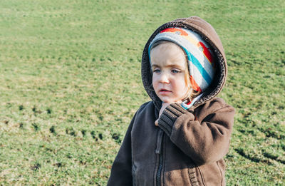 Cute girl wearing warm clothing while looking away on land