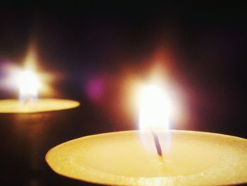 Close-up of lit candle in dark room