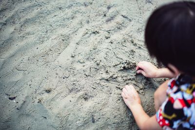 High angle view of hands on sand