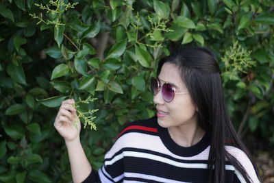 Young woman touching leaves