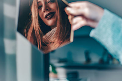 Portrait of young woman using mobile phone at home