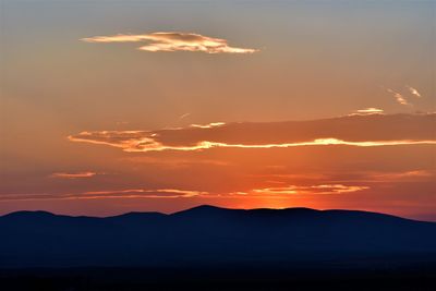 Scenic view of silhouette mountains against romantic sky at sunset