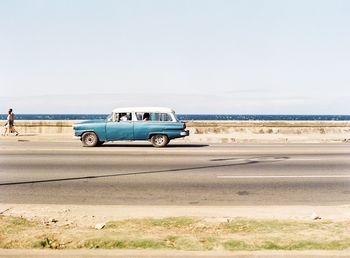 Vintage car on beach against clear sky