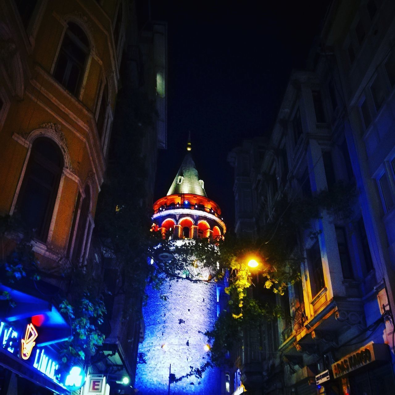 LOW ANGLE VIEW OF ILLUMINATED BUILDINGS IN CITY