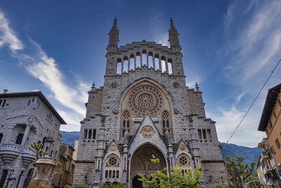 Low angle view of gothic church of sant bartomeu de soller against sky in town