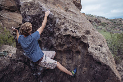 Rear view of man on cliff against mountain