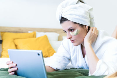 Portrait of young woman using mobile phone at home