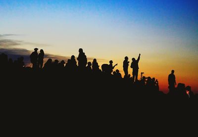 Silhouette people against clear sky during sunset