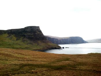 Scenic view of sea and mountains against clear sky