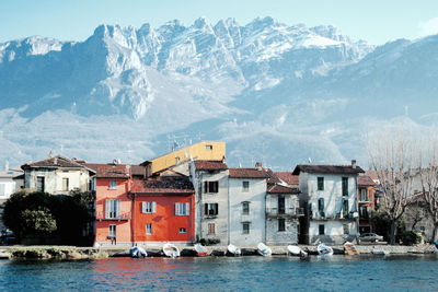 Houses at waterfront with mountain range in background