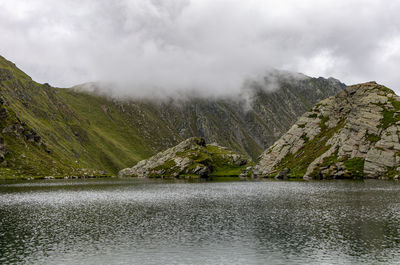 Scenic view of lake by mountains against sky