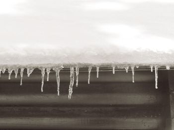 Close-up of frozen water against sky