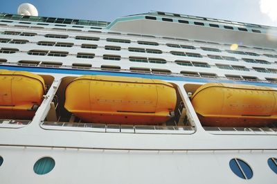 Close-up of yellow car against blue sky