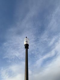 Low angle view of bird perching on pole against sky