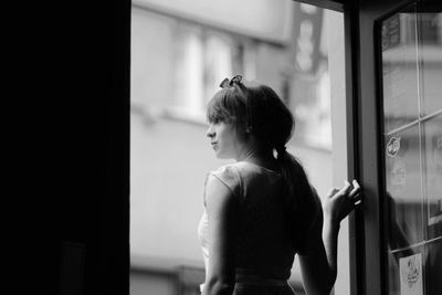 Young woman standing at doorway