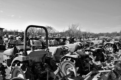 Panoramic view of abandoned cars on field against sky