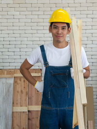 Portrait of smiling man standing against wall