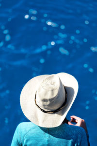 Rear view of woman wearing hat while standing by railing