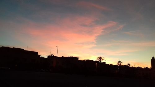 Silhouette buildings against sky during sunset