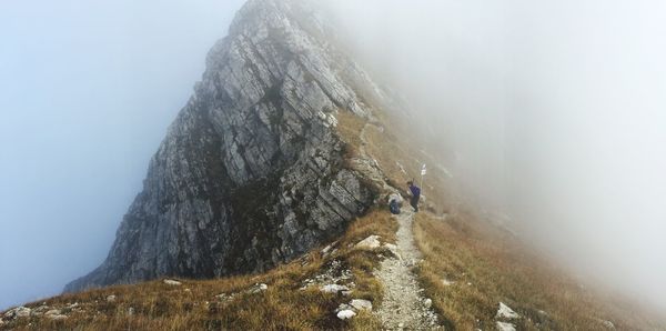 Low angle view of person on cliff during winter