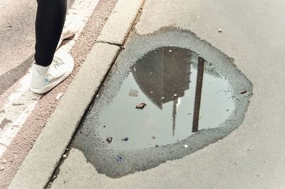 Low section of person standing on wet street