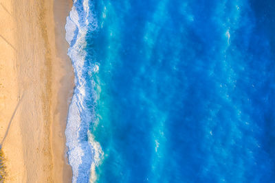 Aerial top down view of turquoise waters of milos beach, lefkada island, greece
