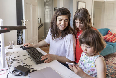 Mother and daughters looking at cell phone