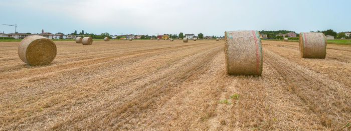 Hay bales on field against sky