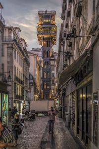 People walking on street amidst buildings in city