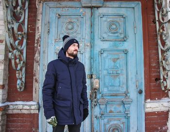 Man standing against closed door of building
