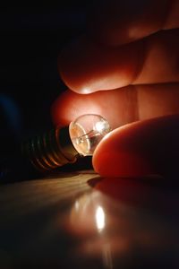 Close-up of hand holding light bulb