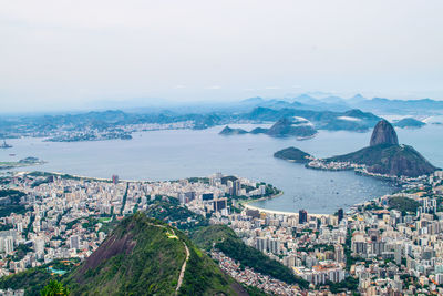 High angle view of city by sea against sky