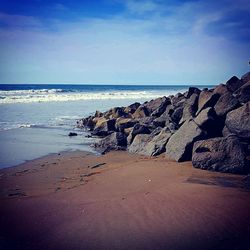 Scenic view of beach against blue sky