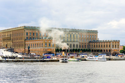 Boats in city against sky