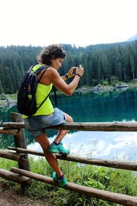 Side view of man on lake against trees