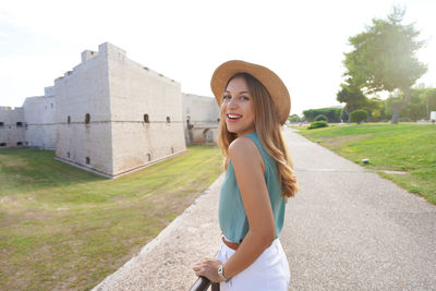 Portrait of beautiful young woman with barletta castle on the background, apulia, italy.