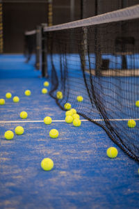 Tennis ball on the floor after a match - padel balls - yellow tennis balls in court on blue turf