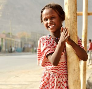 Smiling girl standing with hands clasped