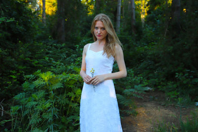 Portrait of beautiful woman standing in forest