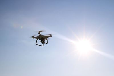 Low angle view of drone flying against sky