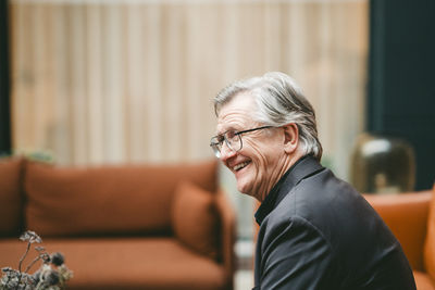 Young man looking away while sitting at home