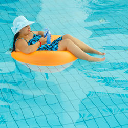 High angle view of young woman sitting on swimming pool