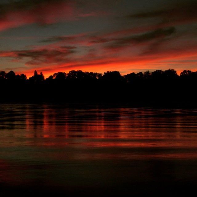 sunset, water, tranquil scene, scenics, reflection, silhouette, sky, tranquility, beauty in nature, waterfront, lake, orange color, tree, idyllic, nature, cloud - sky, dramatic sky, rippled, dusk, cloud