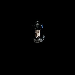 Close-up of illuminated electric lamp against black background