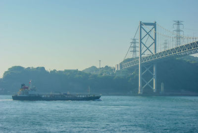 Boats in sea against clear sky