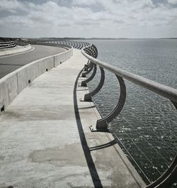 Railing by sea against sky