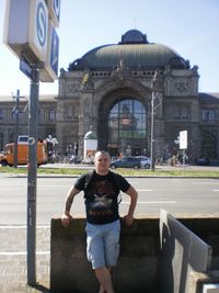 Portrait of man standing against building in city