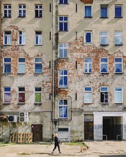 Full length of man walking on street against building